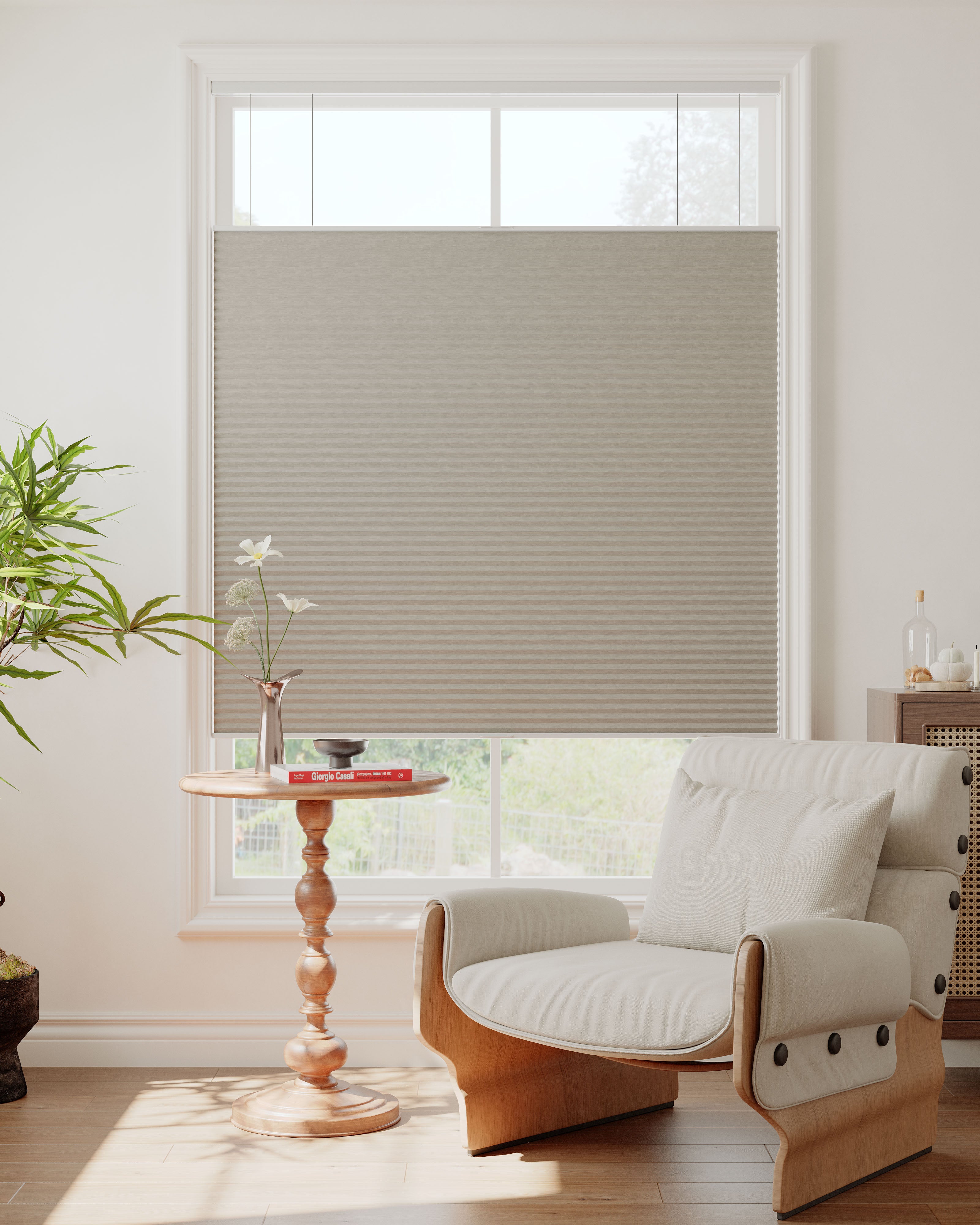Stylish honeycomb cellular shades partially raised on a window.